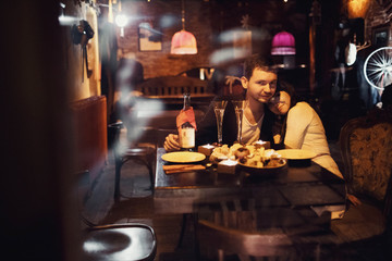 beautiful and young couple sitting in a cozy cafe