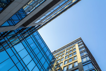 Fototapeta premium Modern architecture with glass facade under blue sky.