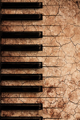 music background. piano keys on crack soil texture