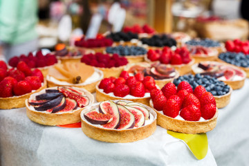 Fruit and berry tarts dessert tray assorted outdoors