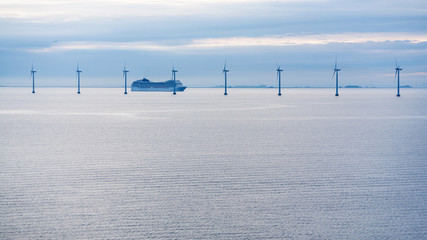 ferry near offshore wind farm in morning twilight