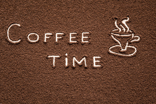 Fototapeta Drawn mug with inscription coffee time created from ground coffee in the kitchen. Enjoying a coffee break.