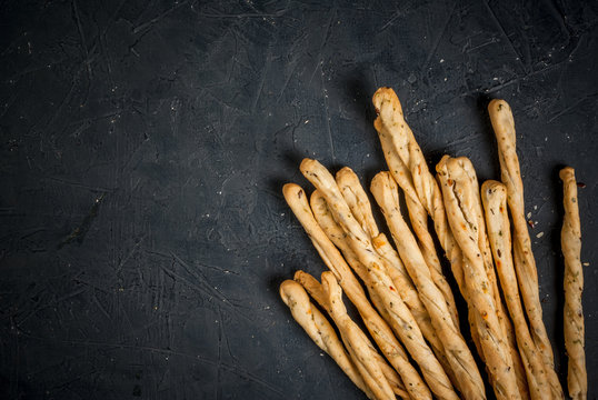 Traditional Italian snack, bread - grizzini. In the kitchen chopping board. On a dark stone table, copy space