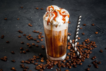 Cold coffee drink frappe (frappuccino), with whipped cream and caramel syrup, with straws and...