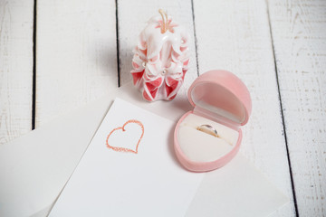 St. Valentine's Day: the offer on a romantic appointment. Two carved candles, pink box and note.