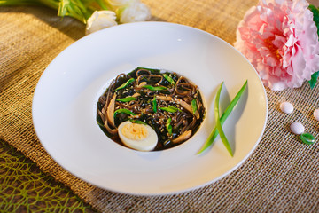 Udon noodle soup with vegetables in white plate Rustic