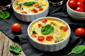 Spinach tomato Frittata on a wood background. tinting. selective focus