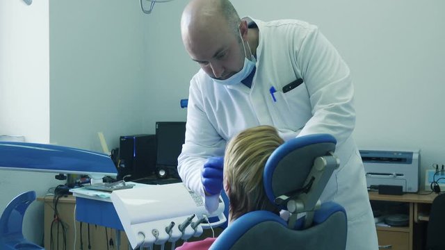 Dentist inserts a dental mouth guard in the patient's mouth and fixes it there