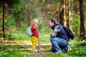 Father and his son walking during the hiking activities in forest