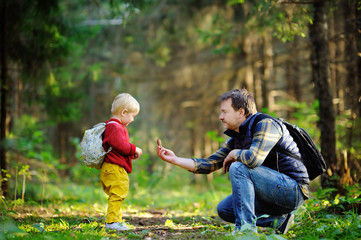 Father and his son walking during the hiking activities in forest