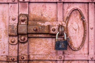 Lock with a latch on an old metal door in red