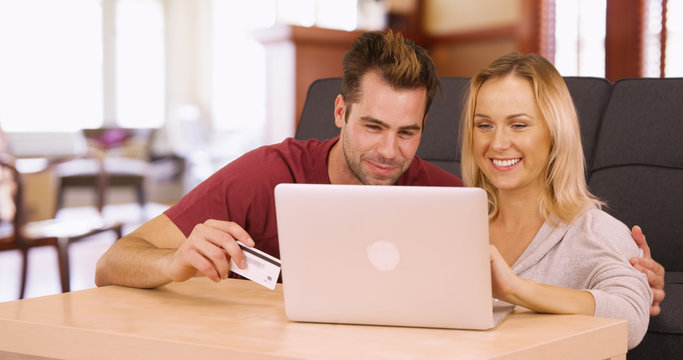 Millennials online shopping together on laptop at home