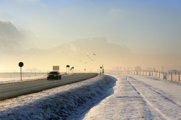 Samochód osobowy na drodze zimą w górach. - obrazy, fototapety, plakaty