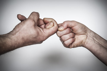Fingerhakeln / Hand von Mann und Frau loesen ein Konflikt mit Fingerhakeln.
