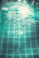 Swimming pool water surface with bubbles and ripples in transparent turquoise water with net pattern in vintage style