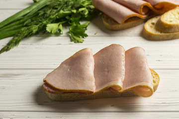 Sandwiches, Herbs and Bread on White Wooden Background
