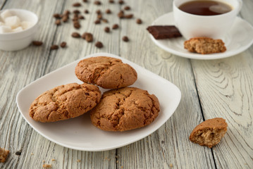 Homemade oat cookies with coffee on a wooden background