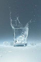 ice cube falls in a glass of water