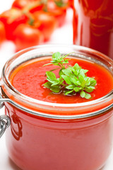 Glass  jar with tomato paste and cherry tomatoes isolated on whi