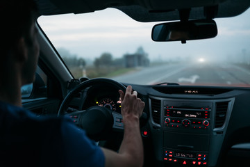 Man driving a car in fog. Back view