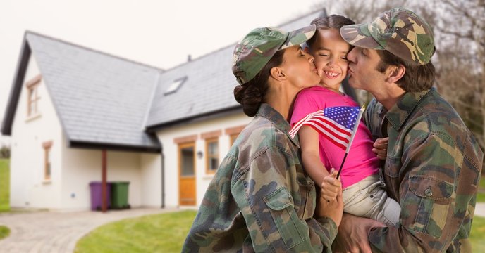 Happy parents in soldiers uniform kissing their daughter