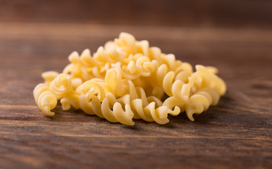 fusilli pasta on wooden background