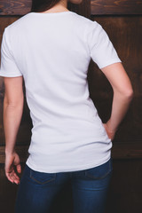 Young woman wearing blank white t-shirt with area for your logo or design, mock-up of template white t-shirt, back view