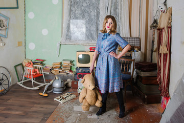 portrait of beautiful blonde woman with old teddy bear in soviet union interiour 