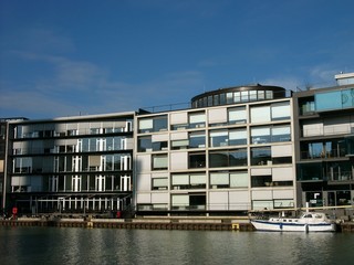 Moderne Bürogebäude mit Rollos und Jalousien als Sonnenschutz bei blauem Himmel und Sonnenschein...