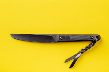 Black knife on yellow background. survival and bushcraft concept