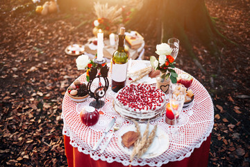 Romantic dinner for two. Desk, flowers, candles, glasses and wine. Evening light. Very romantic photo at sunset