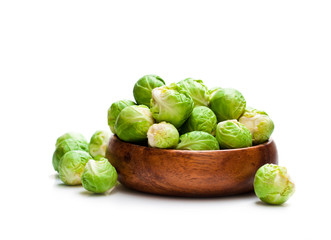 Fresh  brussels sprouts in wooden bowl isolated on white backgro