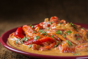 Stew made from backed red peppers with sour cream and parsley