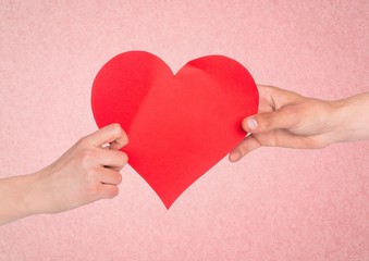 Hand of couple holding red heart