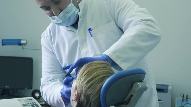 Dentist adjusts the position of the mouth guard in the patient's mouth