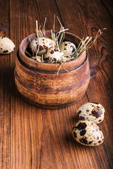 Quail eggs in a wooden bowl on the table
