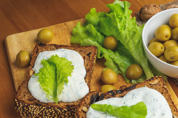 Green olives and Vegetarian sandwiches with homemade bread, cheese sauce 