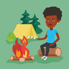 Woman roasting marshmallow over campfire.