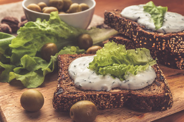 Sandwiches of homemade bread with cheese sauce or cream, lettuce, walnuts, olive