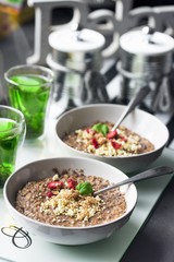 Chocolatiers breakfast for two person with oatmeal, puffed rice, cereals , dried strawberries and  tea prepared in a white bowl. Big inscription Dream above.