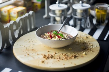 Chocolatiers breakfast   with oatmeal, puffed rice, cereals , dried strawberries   prepared in a white bowl. Big inscription Dream above.