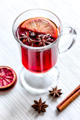 mulled wine with spices in cup on wooden background