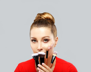Portrait of beautiful woman holding make-up brushes.Putting makeup .Contouring.