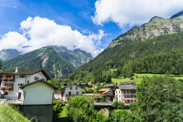 Fototapeta na wymiar Small Swiss town in the mountains under blue skies and fluffy clouds