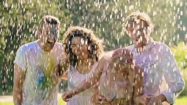 Group of friends covered in colored paint enjoying time at summer pool party