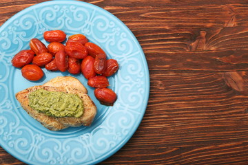 tasty baked chicken breasts covered with basil pesto sauce