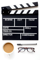 Screenwriter desktop with movie clapper board white background top view