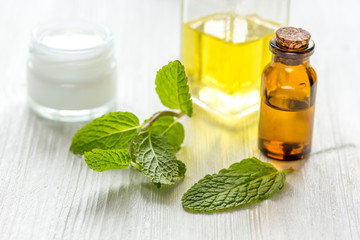 organic cosmetics with herbal extracts of mint on wooden background