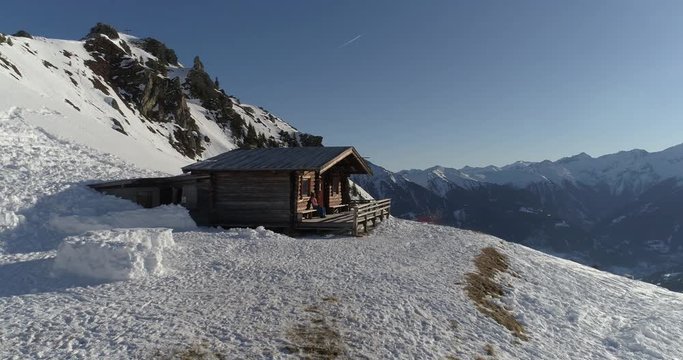 Mountain shelter at dawn with the girl sitting and looking at the sunrise