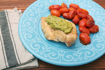 tasty baked chicken breasts covered with basil pesto sauce